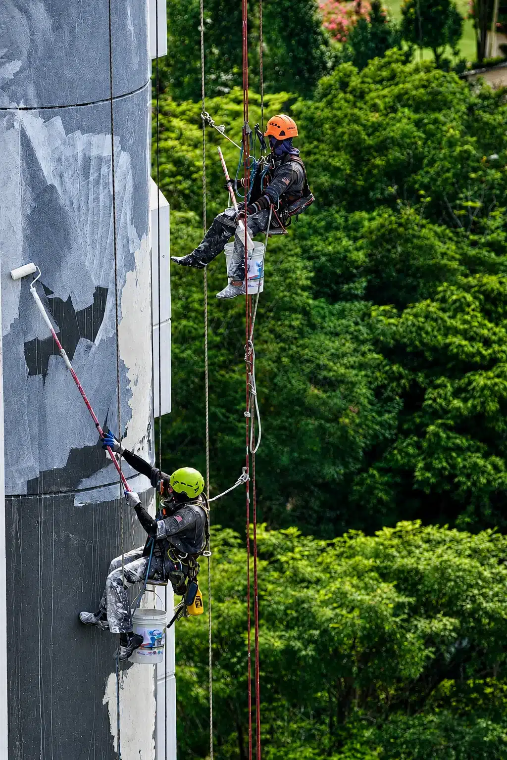 Rope access painters restoring an exterior wall