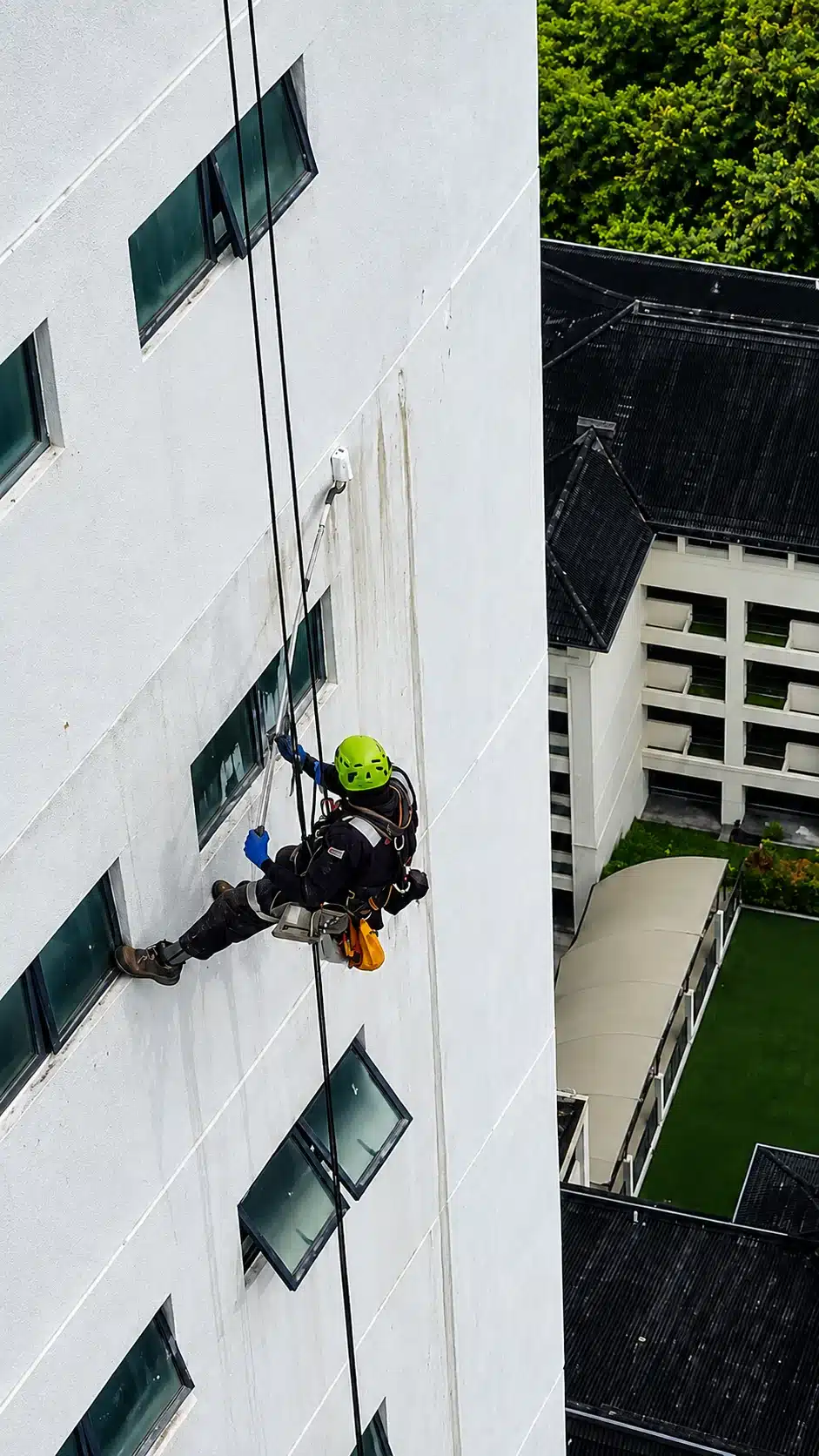 Rope access technician preparing a building exterior